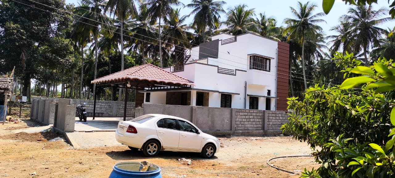Completed villa with tiled portico surrounded by a coconut grove