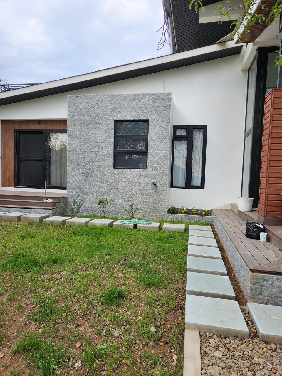 House exterior with stone accent wall and landscaped garden path